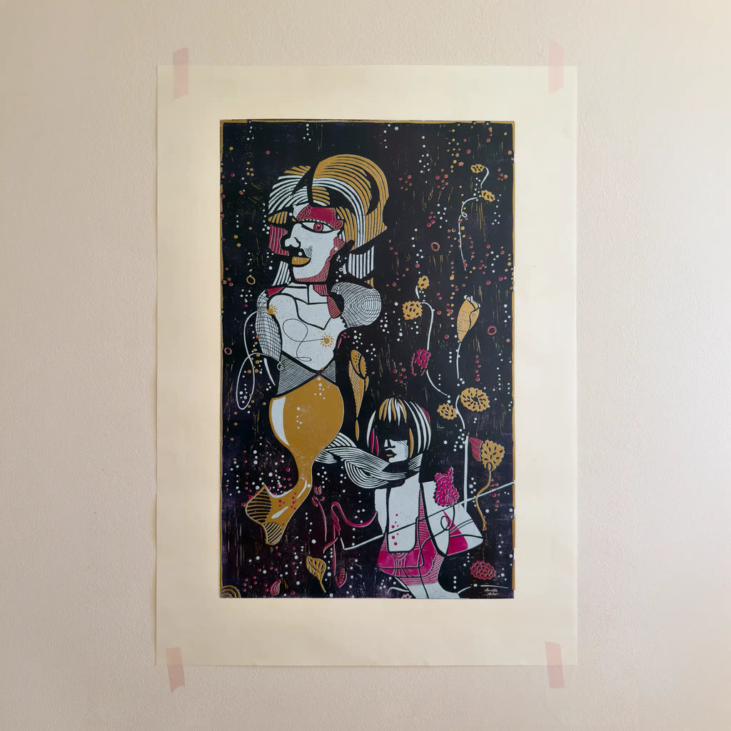 The linocut “Underwater Love” in gold and purple, attached to a beige wall with pink tape.
