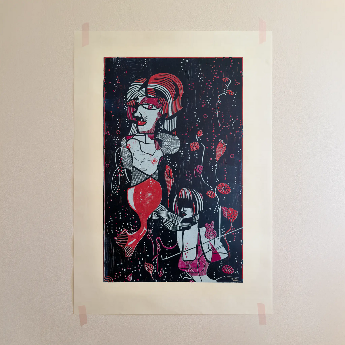 The linocut “Underwater Love” in red and blue, attached to a beige wall with pink tape.
