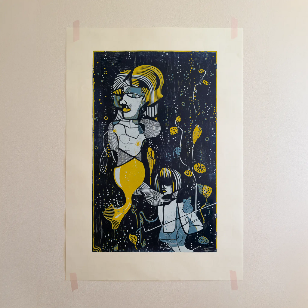 The linocut “Underwater Love” in yellow and blue, attached to a beige wall with pink tape.