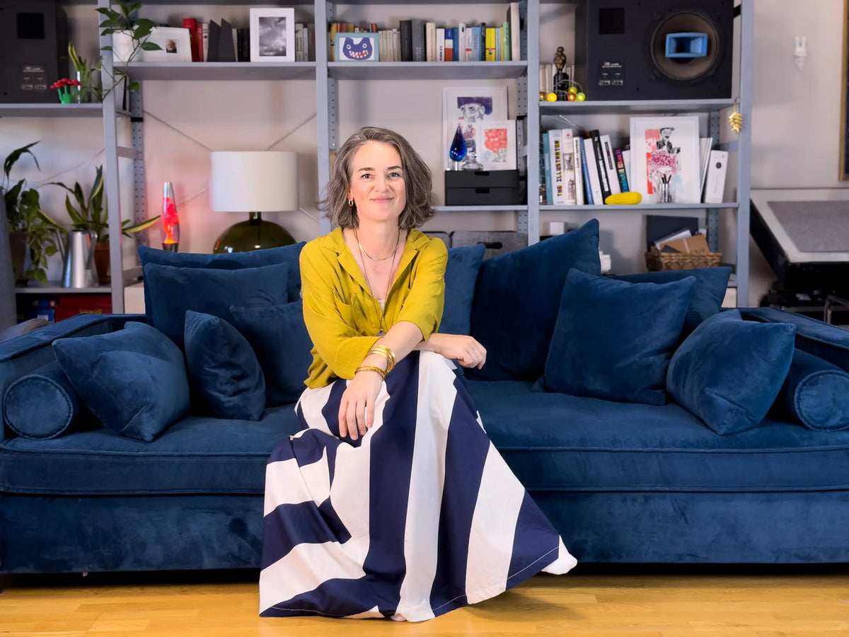 Portrait of Aurelia Astor on a blue sofa in her atelier